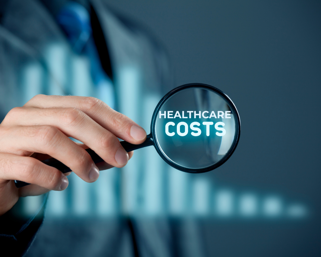 a hand holding a magnifying glass with the words "healthcare costs"